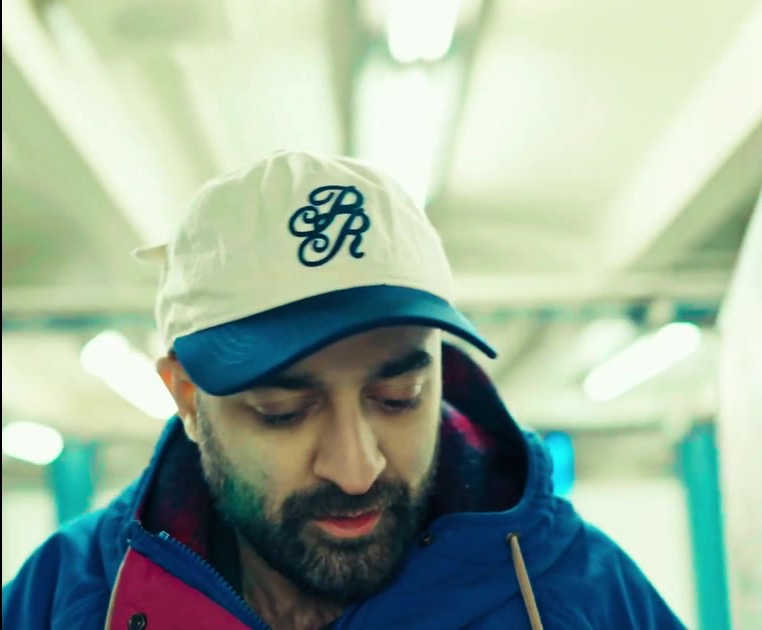 Younis Dhaher wearing a cap and blue jacket
